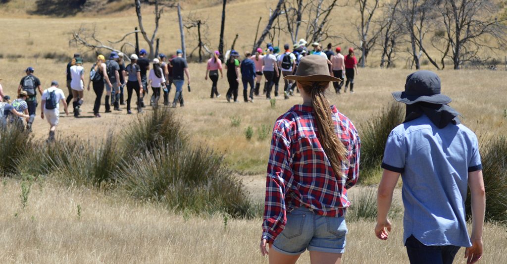 Two Young Rural Leaders program participants walk together through grass.