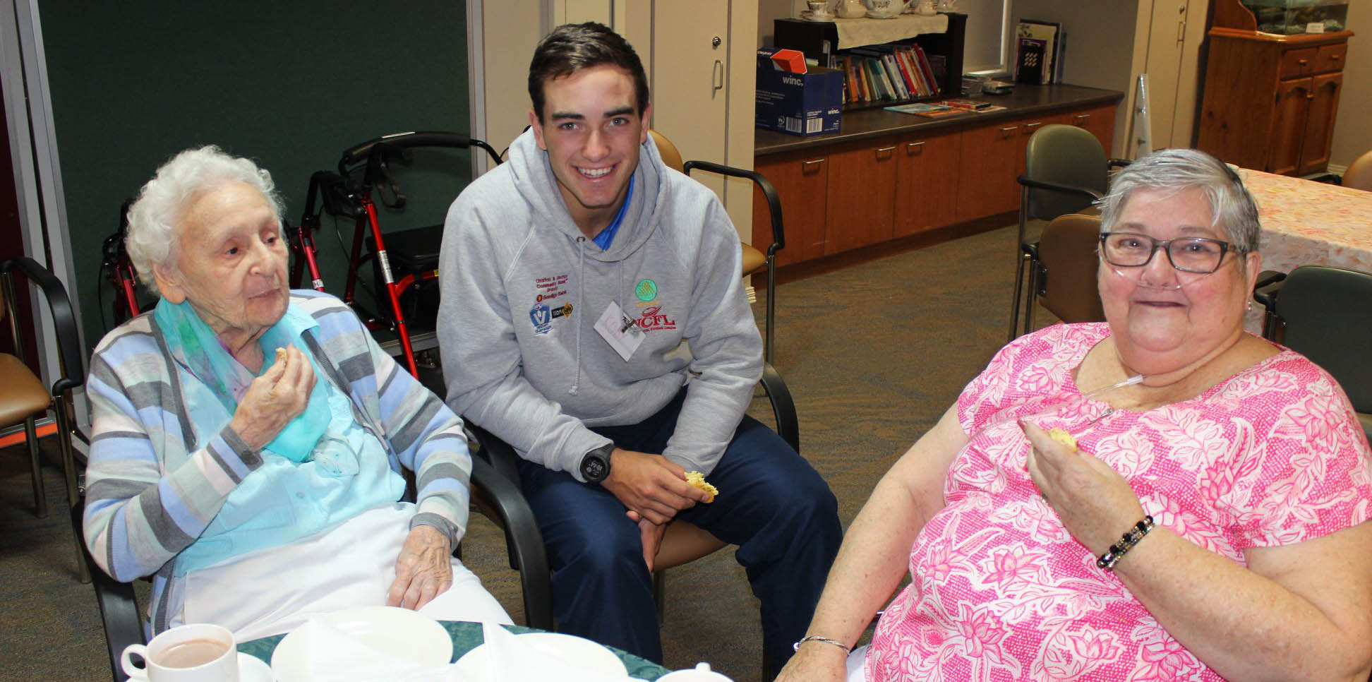Youth leadership program participant talking to elders at nursing home.